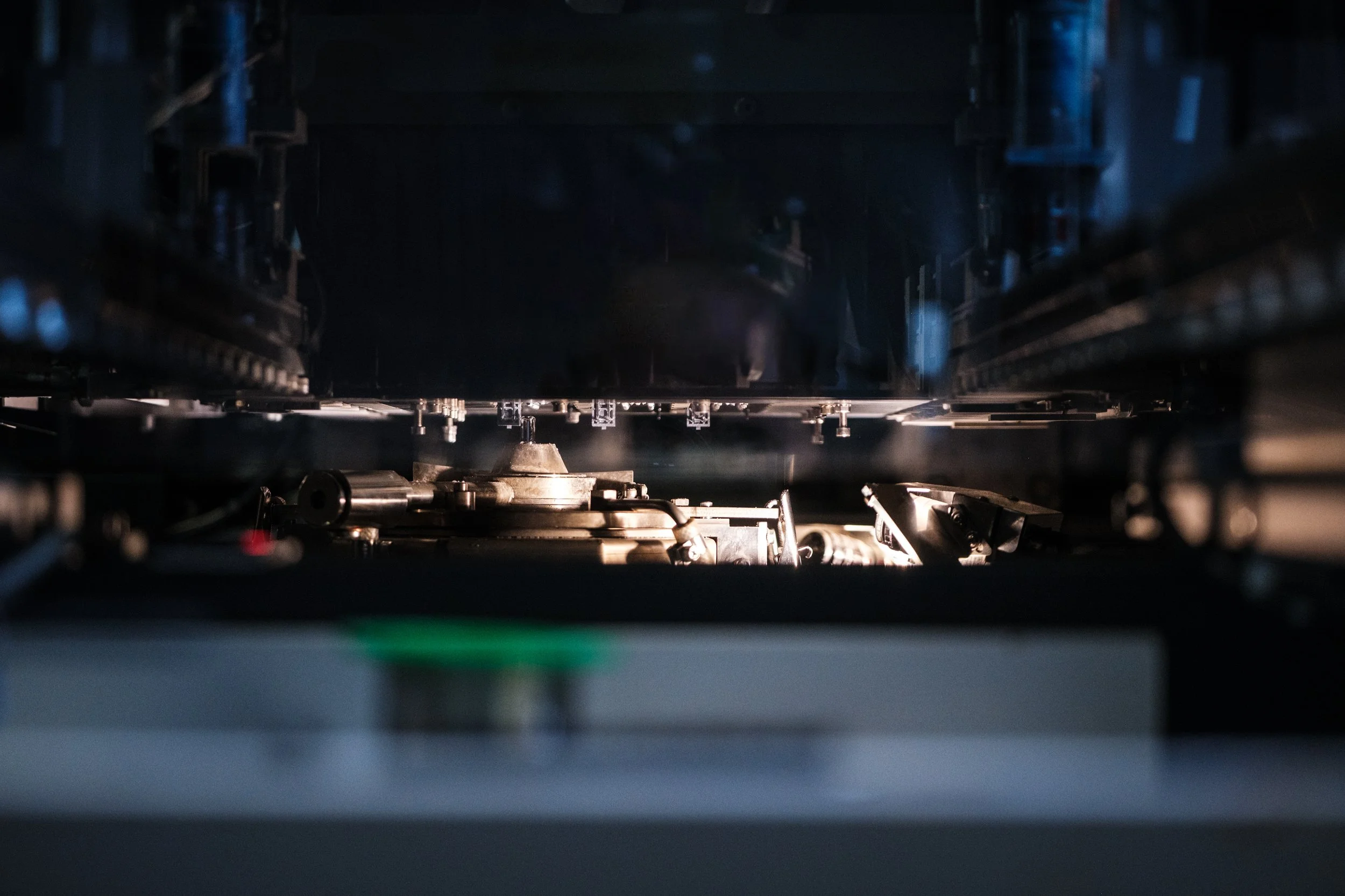 Nahaufnahme eines technischen Geräts im Inneren einer Maschine mit Metallteilen und Schrauben.
