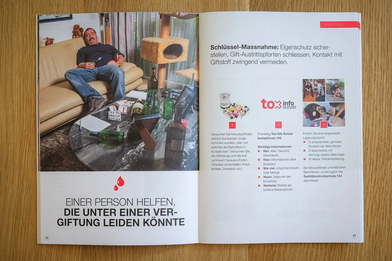 Ein Mann liegt bewusstlos auf einem Sofa, umgeben von leeren Alkoholflaschen und Tabletten, in einem Wohnzimmer.